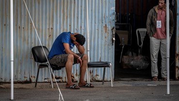 صورة ارشيفية وتعبيرية- ناجون تجمعوا في مستودع بميناء بلدة كالاماتا بعد غرق مركب قبالة اليونان (15 حزيران 2023، أ ف ب). 
