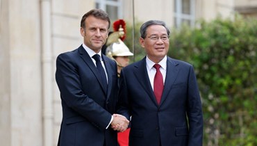 ماكرون (إلى اليسار) مستقبلا تشيانغ في قصر الإليزيه في باريس، على هامش قمة الميثاق المالي العالمي الجديد (22 حزيران 2023، أ ف ب).