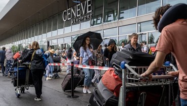 مسافرون انتظروا بالصف لدخول مطار جنيف الدولي في جنيف وسط إضراب لعمال المطار (30 حزيران 2023، أ ف ب).