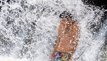 صبي داخل حمام سباحة في تكساس، حيث دفعت درجات الحرارة العالية دائرة الأرصاد الجوية الوطنية إلى إصدار تحذيرات شديدة (أ ف ب). 