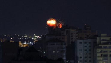  اللّهب يتصاعد فوق المباني بعد الغارات الجوية الإسرائيليّة في مدينة غزة (أ ف ب). 