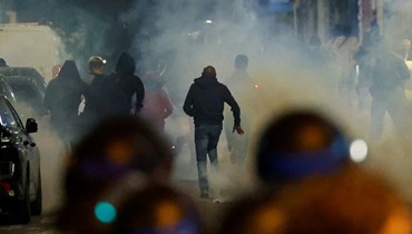 متظاهرون يركضون في باريس بينما يستخدم الشرطيون الغاز المسيل للدموع لتفريقهم (2 تموز 2023، أ ف ب).