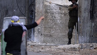 متظاهر فلسطيني يرشق جنديا اسرائيليا بالحجارة عقب احتجاج ضد مصادرة اسرائيل للاراضي الفلسطينية في بلدة كفر قدوم في الضفة الغربية المحتلة (7 تموز 2023، أ ف ب). 