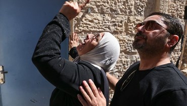 السيدة نورا صب لبن ونجلها بعد إخراجهما بالقوّة من منزلهما في القدس الشرقية (أ ف ب).