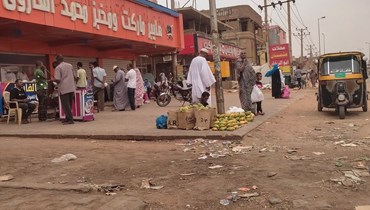  أشخاص يصطفّون للحصول على الخبز أمام مخبز في أم درمان، السودان (أ ف ب). 