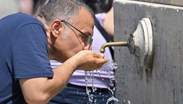 رجل يشرب الماء من نافورة في الفاتيكان (9 تموز 2023، أ ف ب).