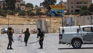 جنود إسرائيليون يغلقون الطريق المؤدية إلى بلدة جناتة بالضفة الغربية المحتلة جنوب بيت لحم، في أعقاب إطلاق نار على مفترق تقوع (16 تموز 2023، أ ف ب).