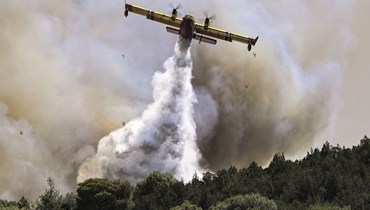 طائرة إطفاء ترش الماء على حريق في ديرفينوشوريا شمال غرب أثينا (19 ايلول 2023، أ ف ب).