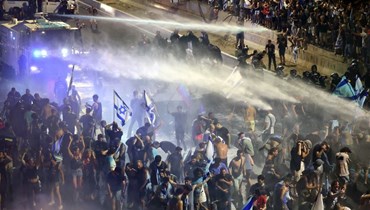 عناصر من الشرطة الاسرائيلية يرشون متظاهرين بالمياه خلال احتجاج في تل أبيب على خطة الحكومة للإصلاح القضائي (24 تموز 2023ـ أ ف ب).