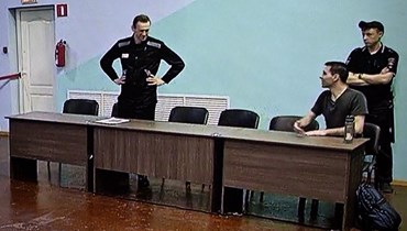 نافالني (إلى اليسار) يظهر على شاشة بينما كان ينتظر الاستماع إلى حكم عليه في مستعمرة IK-6 الجنائية شرق موسكو (4 آب 2023ـ أ ف ب). 