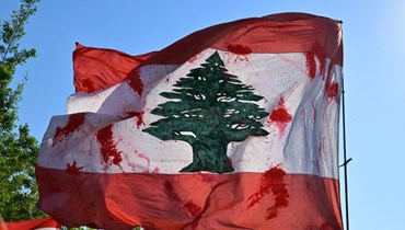 علم لبناني رفع في مسيرة ضحايا انفجار 4 آب. (نبيل إسماعيل- النهار)