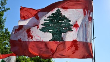 العلم اللبناني ملطّخاً بالدماء خلال مسيرة الأهالي إحياءً للذكرى الثالثة لانفجار 4 آب (نبيل إسماعيل). 