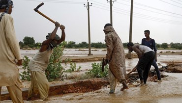 سكان يحفرون خندقاً لإحتواء السيول في أم درمان السبت. (أ ف ب)