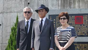 أسو (في الوسط) يقف لالتقاط صورة مع آني لي (الى اليمين)، الابنة الثانية للرئيس التايواني السابق لي تنغ هوي، خلال زيارته قبره في مقبرة عسكرية في مدينة تايبيه الجديدة (7 آب 2023، ا  ف ب).