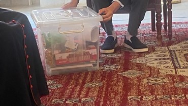  وزير التربية عباس الحلبي يحمل صندوقاً بلاستيكياً مختوماً (النهار).