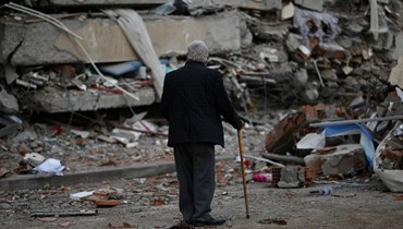رجل يمرّ بين أنقاض أبنية منهارة في كهرمان مرعش (4 آذار 2023 - أ ف ب).