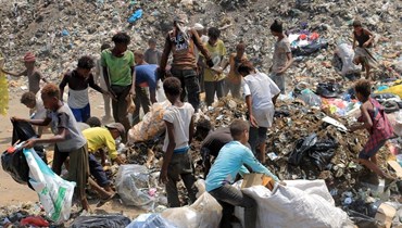 شبان يجمعون مواد قابلة لإعادة التدوير في مكب نفايات في مدينة الحديدة الساحلية اليمنية (15 آب 2023، أ ف ب).