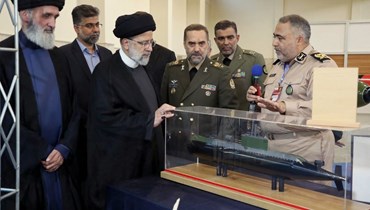 رئيسي (الثاني من اليسار) ووزير الدفاع محمد رضا قرائي أشتياني (في الوسط) خلال احتفال بإنجازات صناعة الدفاع الإيرانية في طهران (22 آب 2023، أ ف ب).
