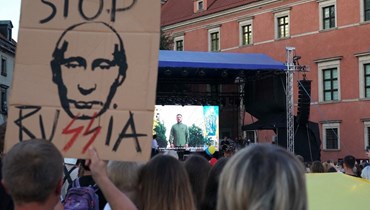 زيلينسكي يظهر على شاشة بينما تجمع اشخاص في ميدان زامكوي في وارسو، للاحتفال بعيد استقلال أوكرانيا (24 آب 2023، أ ف ب).
