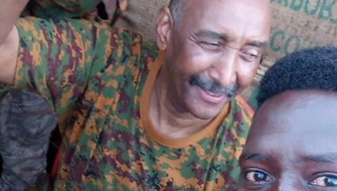 من الارشيف- صورة نشرتها صفحة القوات المسلحة السودانية في الفايسبوك، وتظهر البرهان (الى اليسار) يلتقط صورة مع مدني في الخرطوم خلال جولة فيها (24 آب 2023، أ ف ب).