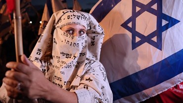 نشطاء ينظّمون احتجاجاً يندّدون فيه بالتمييز ضدّ المرأة في خدمات النقل العام  بالقرب من تل أبيب (أ ف ب). 