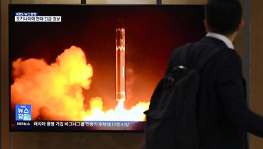 صورة ارشيفية- رجل يمر أمام شاشة في محطة قطارات في سيول تعرض لقطات أرشيفية لاختبار صاروخي لكوريا الشمالية (24 آب 2023، أ ف ب).