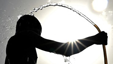 صورة ارشيفية- رجل يستحم في يوم صيفي حار في نيودلهي (15 ايار 2022، أ ف ب).