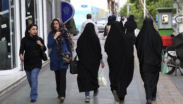 صورة ارشيفية- نساء إيرانيات يمشون على رصيف وسط طهران، (26 نيسان 2016، أ ب). 