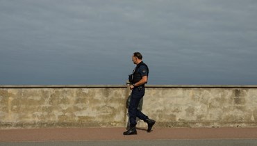 شرطي فرنسي يقوم بدورية على شاطئ بولونيو سور مير شمال فرنسا، للبحث عن مهاجرين يحاولون عبور القناة الإنكليزية للوصول إلى بريطانيا (29 آب 2023، أ ف ب).