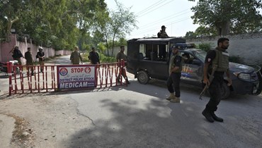 شرطيون وقفوا عند نقطة تفتيش على الطريق المؤدي إلى سجن المنطقة في أتوك في باكستان (30 آب 2023، أ ب). 