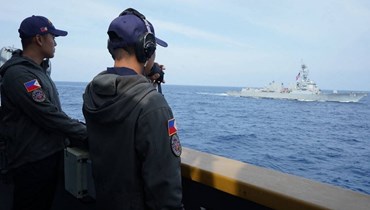 عناصر من البحرية الفيليبينية ينظرون إلى المدمرة التابعة للبحرية الأميركية "يو إس إس رالف جونسون" (الى اليمين) والفرقاطة البحرية الفيليبينية "بي آر بي خوسيه ريزال" خلال ابحارهما في المياه غرب بالاوان في بحر الصين الجنوبي (4 ايلول 2023، أ ف ب).
