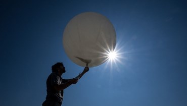 عالم الأرصاد الجوية لوران مولي يستعد لإطلاق منطاد طقس في محطة ميتيو سويس في باييرن غرب سويسرا (7 ايلول 2023، أ ف ب).