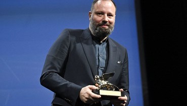 المخرج يورغوس لانثيموس يقف مع الأسد الذهبي لأفضل فيلم "بور ثينغز" خلال حفل توزيع جوائز مهرجان البندقية السينمائي (أ ف ب).