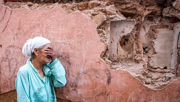 امرأة تقف أمام منزلها المتضرّر من الزلزال في المدينة القديمة، مراكش (9 أيلول 2023 - أ ف ب).