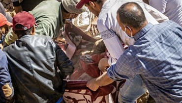 متطوعون ينتشلون جثة من تحت أنقاض منازل منهارة في تفغاغت جنوب غرب مراكش (10 ايلول 2023، أ ف ب).