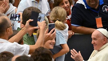 البابا فرنسيس يحيي أطفالا خلال لقاء في قاعة بولس السادس في الفاتيكان (9 ايلول 2023، أ ف ب).