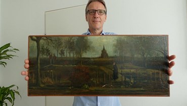 آرثر براند يحمل لوحة فان غوغ. (أ ف ب)