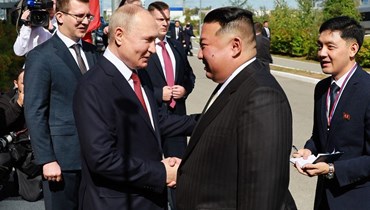 مصافحة بين الرئيس الروسي فلاديمير بوتين والزعيم الكوري الشمالي كيم جونغ أون (أ ف ب).  