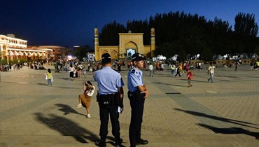 شرطيون وقفوا في الساحة الرئيسية في كاشغار بمنطقة شينجيانغ شمال غرب الصين (15 تموز 2023، أ ف ب).