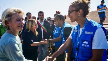 فون دير لايين (الى  اليسار) وميلوني تصافحان أعضاء في المفوضية السامية للأمم المتحدة لشؤون اللاجئين خلال زيارتهما لامبيدوسا (17 ايلول 2023، أ ف ب).