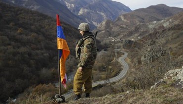 صورة أرشيفية- جندي أرميني وقف للحراسة بجوار علم ناغورنو- كراباخ أعلى تلة بالقرب من تشاريكتار في منطقة ناغورنو- كراباخ (25 ت2 2020، ا ب).