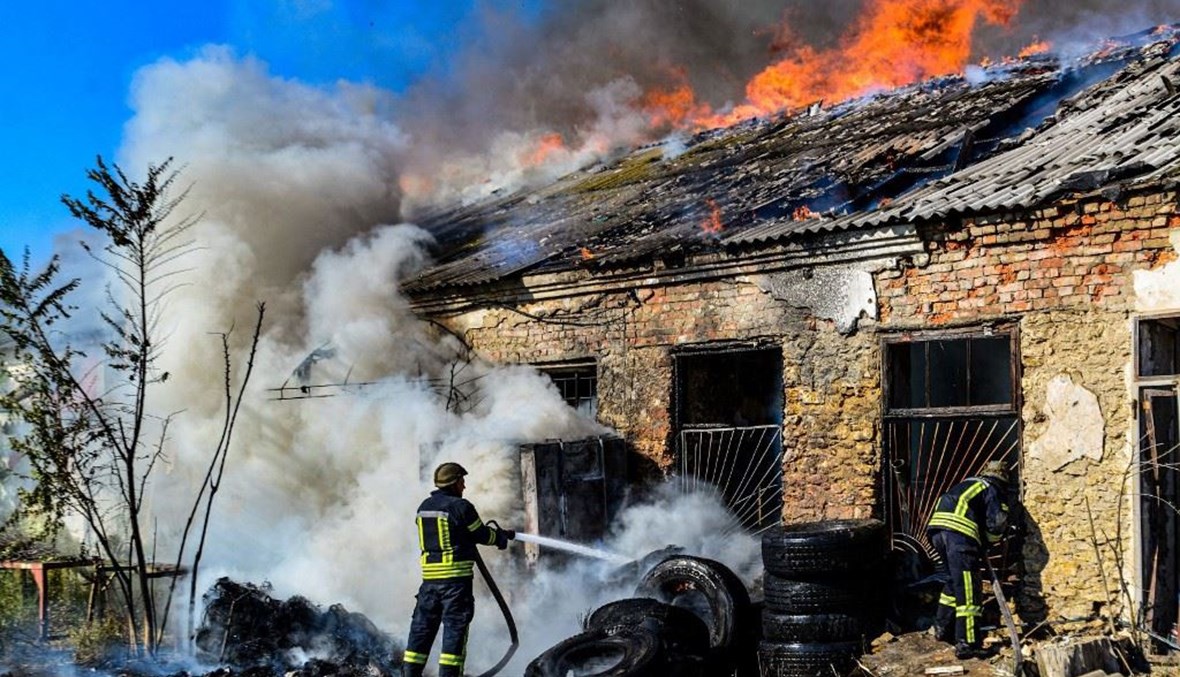 رجال إطفاء يخمدون حريقا في أحد المستودعات بعد قصف في خيرسون (19 ايلول 2023، أ ف ب).