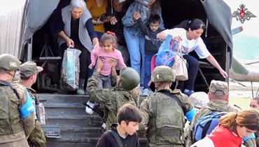 لقطة من فيديو نشرته وزارة الدفاع الروسية في 20 ايلول 2023، يظهر عناصر من قوات حفظ السلام الروسية يساعدون في إجلاء سكان من ستيباناكيرت (أ ف ب).