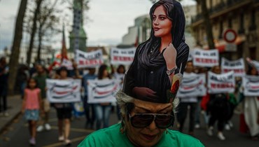 متظاهرة وضعت صورة اميني على رأسها خلال احتجاج ضد النظام الإيراني في ساحة الباستيل في باريس (16 ايلول 2023، أ ف ب). 