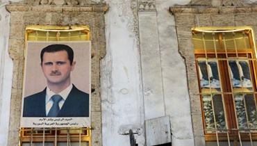ملصق يحمل صورة الرئيس السوري بشار الأسد معلّق على نافذة في سوق الحميدية في دمشق (أ ف ب). 