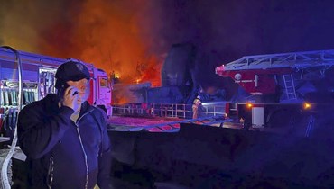 صورة ارشيفية- حاكم سيفاستوبول ميخائيل رازفوزاييف يتكلم على الهاتف المحمول بينما يتصاعد دخان ولهب من حوض بناء السفن المحترق في سيفاستوبول في شبه جزيرة القرم (13 ايلول 2023، أ ب).
