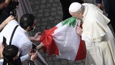البابا فرنسيس يقبّل العلم اللبناني.