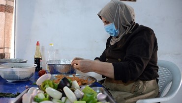 امرأة تعدّ الطعام داخل مطبخ  تديره مجموعة من النساء في مدينة الموصل شمال العراق (أ ف ب). 