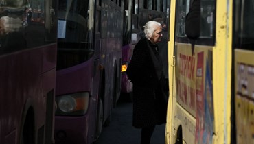  امرأة أرمنية تنتظر بين الحافلات زميلاتها من اللاجئين الأرمن قبل إجلاؤهن في مدن أرمنيّة مختلفة (أ ف ب). 