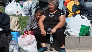 اللاجئون الأرمن ينتظرون في ساحة وسط مدينة غوريس قبل إجلائهم (أ ف ب). 